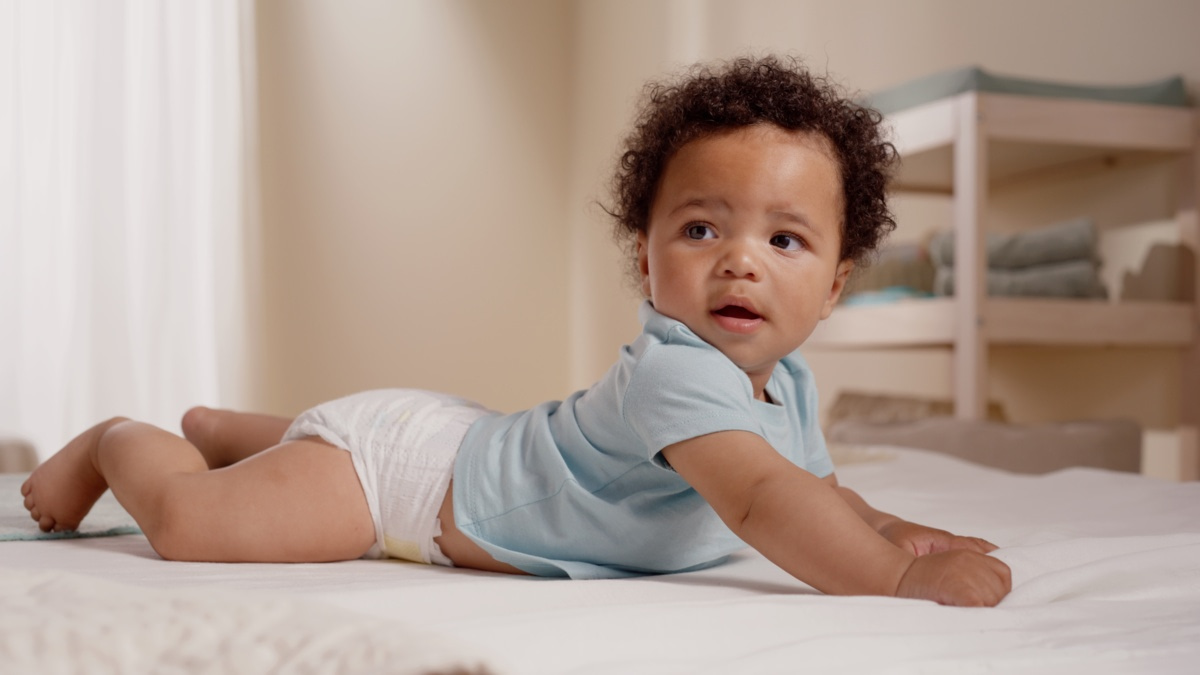 Bébé allongé sur un lit portant une couche jetable
