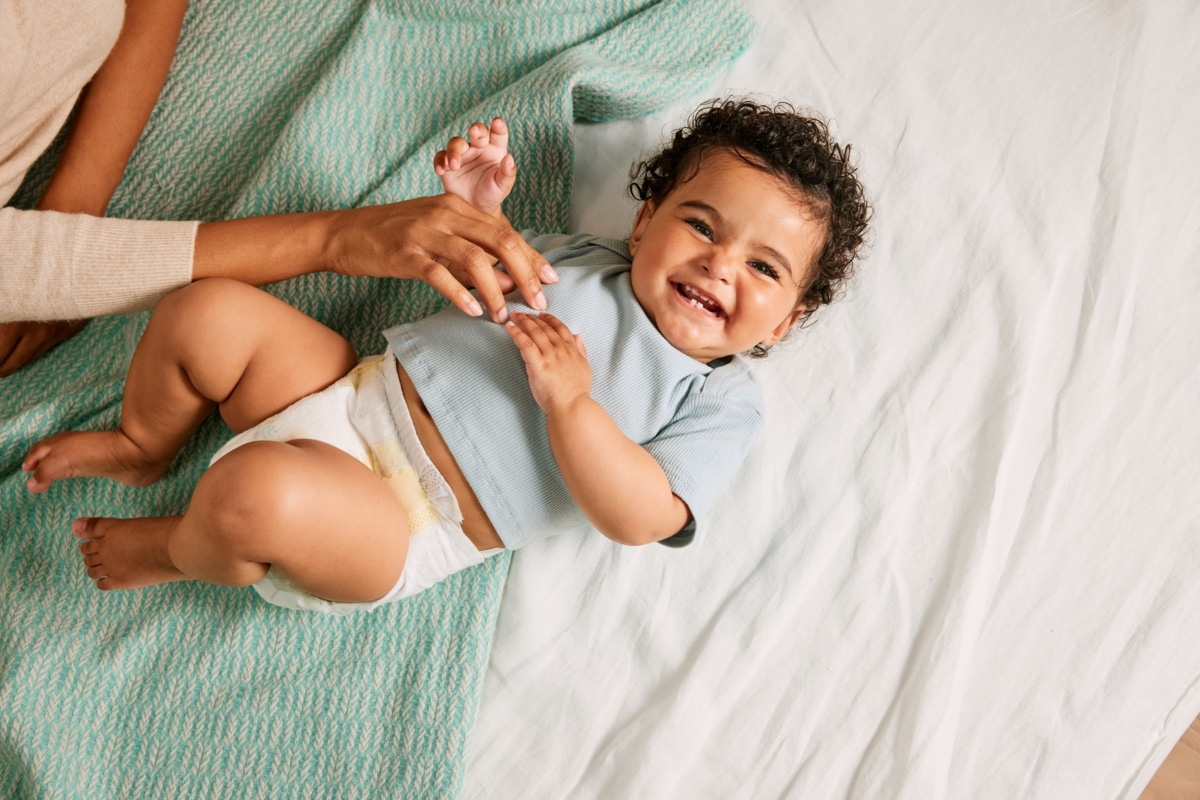 Parent jouant avec son bébé portant une couche lors d'un moment de complicité