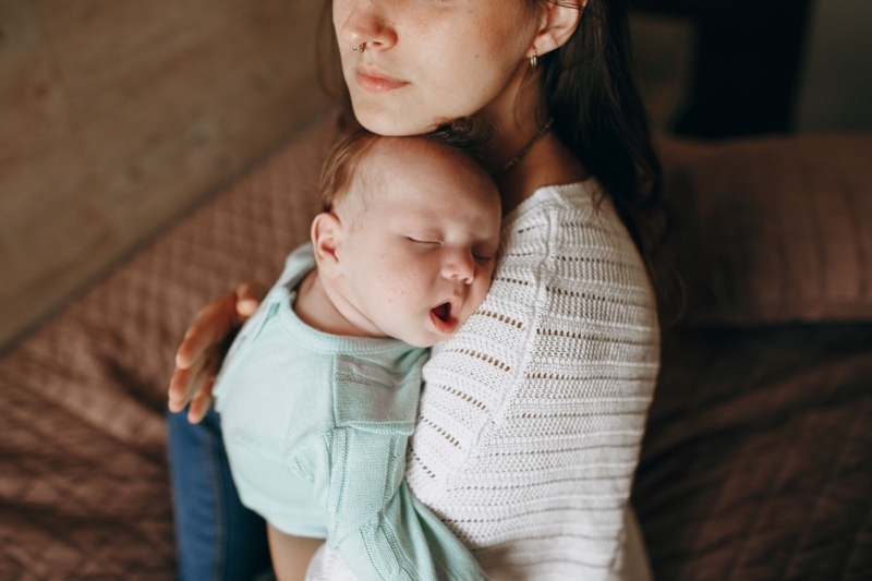 Bébé endormi dans les bras de sa maman