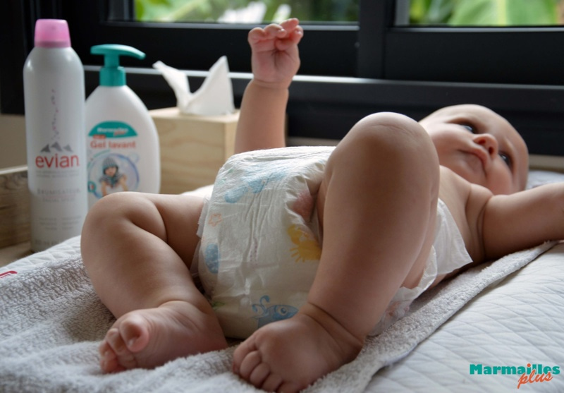 Bébé allongé sur une table à langer pendant le change avec une couche
