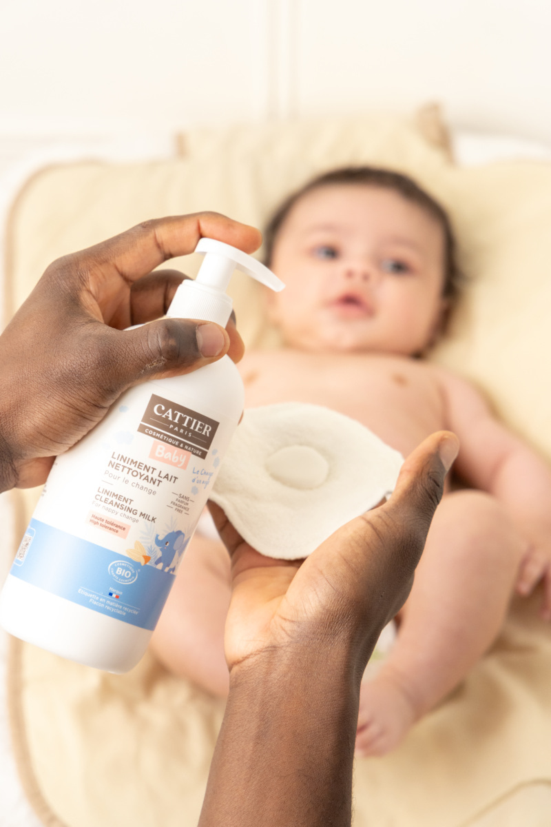 Application de liniment bébé lors du change avec un coton