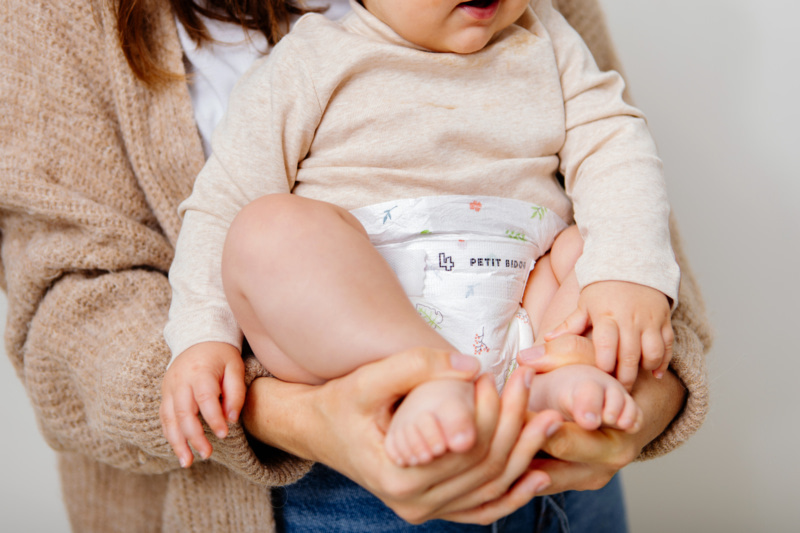 Bébé en couche dans les bras d'un parent