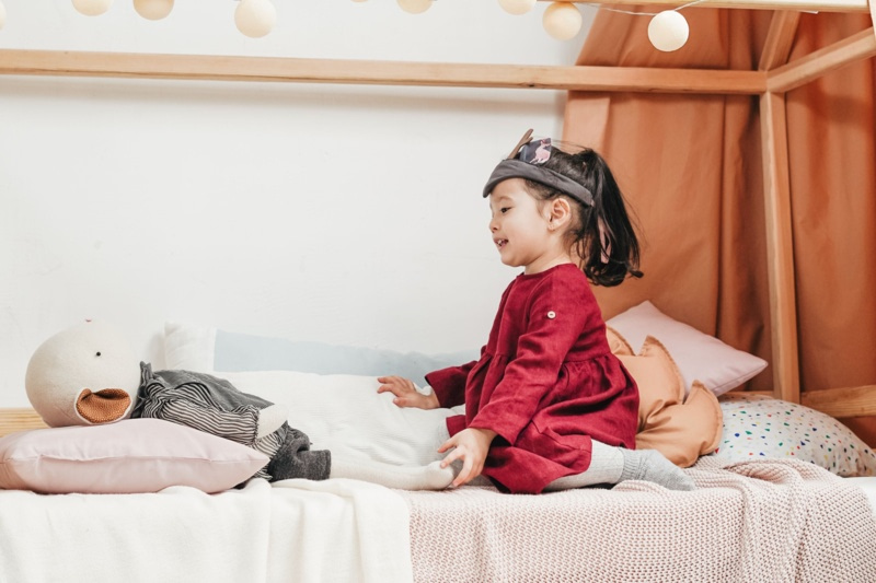 Jeune enfant assise sur un lit cabane dans sa chambre