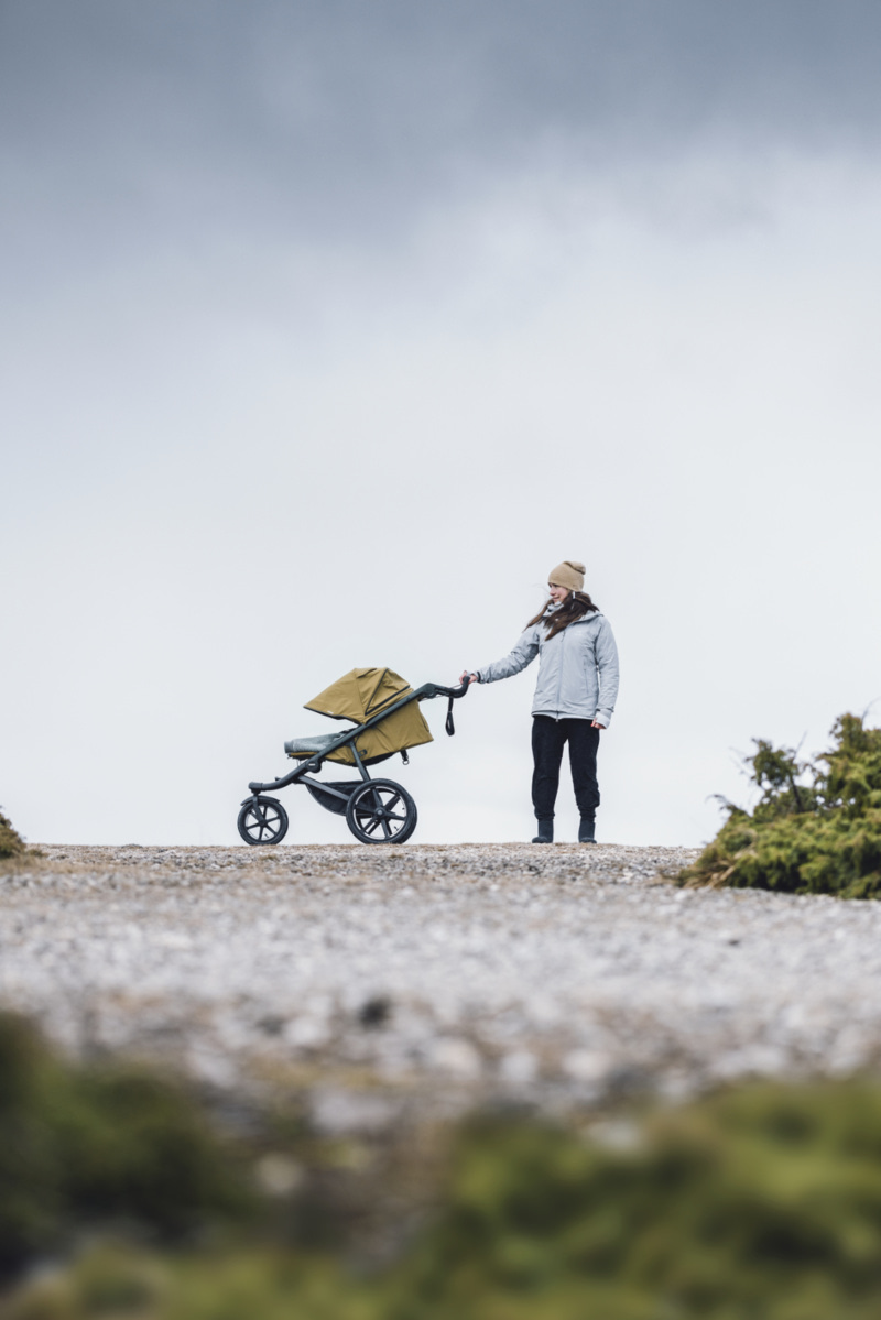 Femme en randonnée dans la montagne avec une poussette Thule Urban Glide 3
