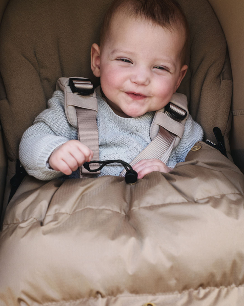 Un bébé emmitouflé dans une chancelière confortable, installé dans la poussette Bugaboo Butterfly 2