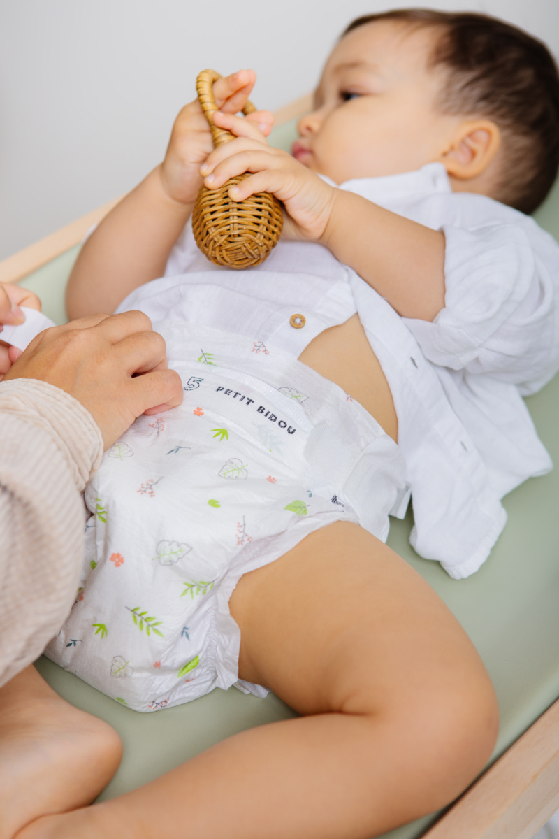 Parent ajustant une couche bébé pour vérifier la bonne taille