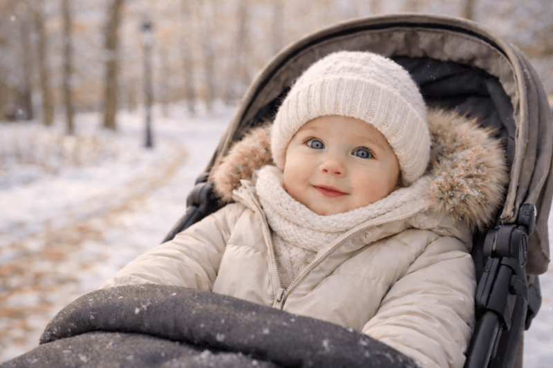 Bébé bien couvert dans une poussette lors d'une promenade en hiver